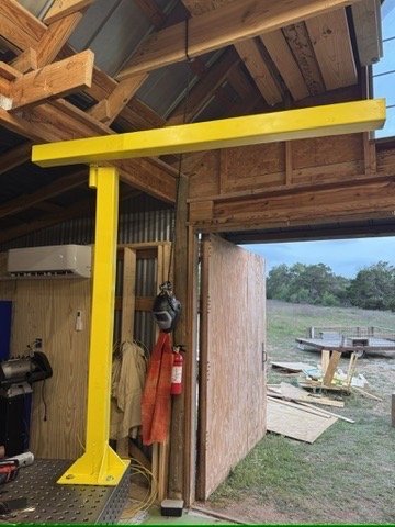 The yellow crane next to the open shop door